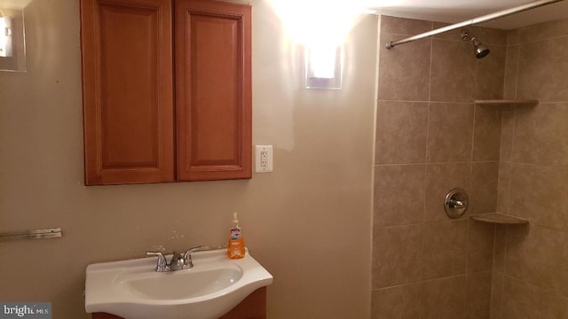 bathroom featuring a tile shower and sink