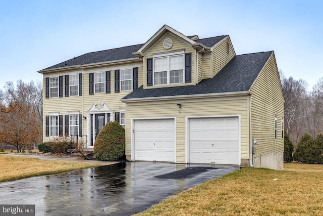 view of front of house with a front yard and a garage