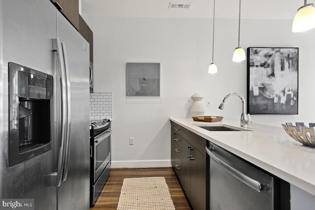 kitchen with stainless steel appliances, backsplash, hanging light fixtures, dark hardwood / wood-style floors, and sink