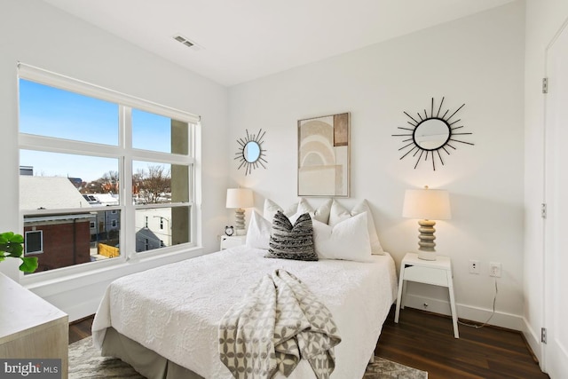 bedroom with dark hardwood / wood-style flooring