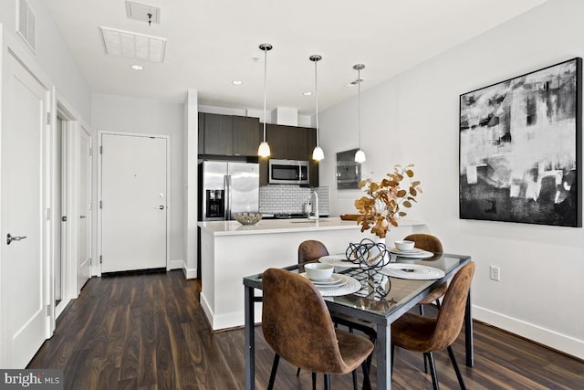 dining space with dark wood-type flooring and sink