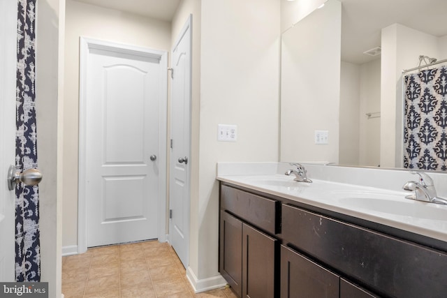 bathroom with tile flooring and dual vanity