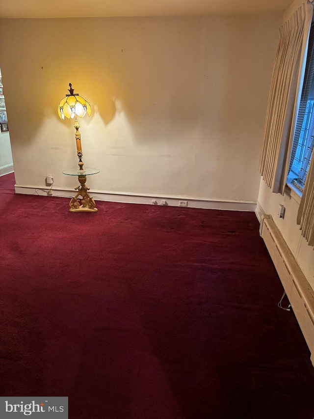 spare room featuring carpet flooring and baseboard heating