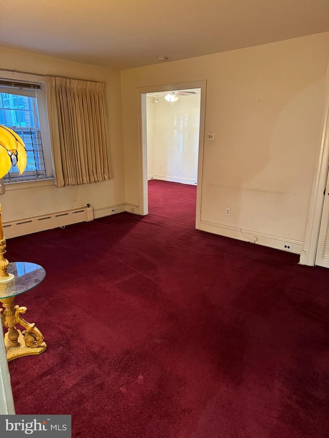 carpeted spare room featuring a baseboard radiator