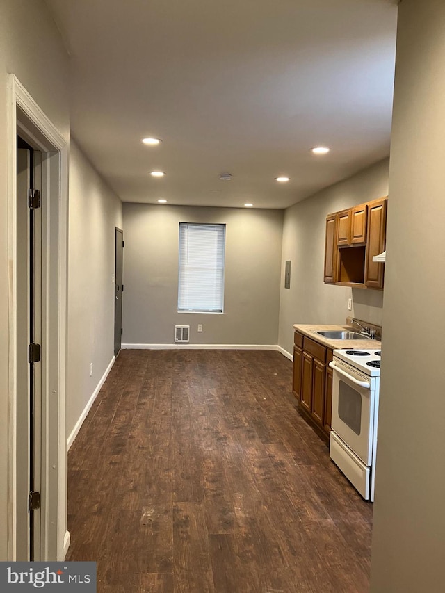 kitchen featuring dark hardwood / wood-style flooring, white range with electric cooktop, and sink