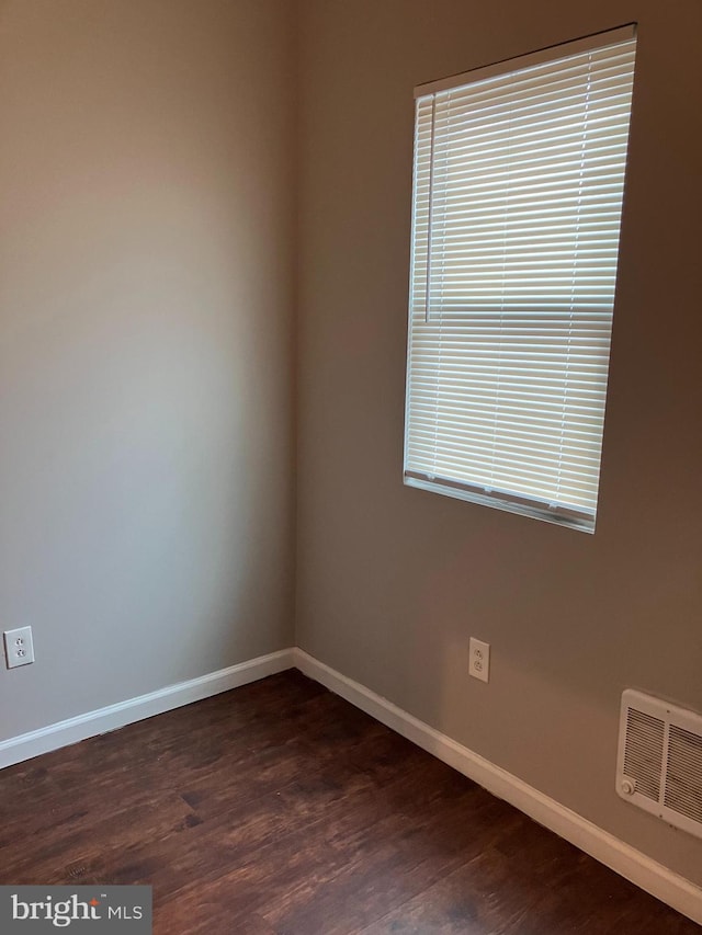 spare room with dark wood-type flooring