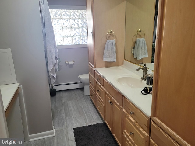 bathroom with toilet, wood-type flooring, vanity, and a baseboard heating unit