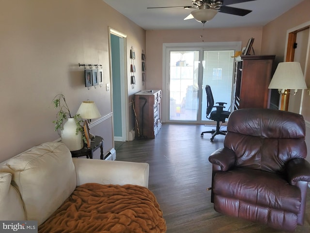 living room featuring ceiling fan, baseboard heating, and dark wood-type flooring