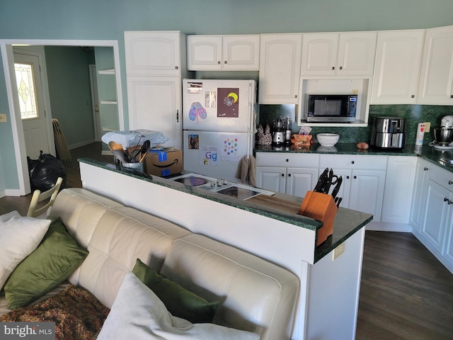 kitchen featuring dark hardwood / wood-style floors, white refrigerator, tasteful backsplash, and white cabinetry