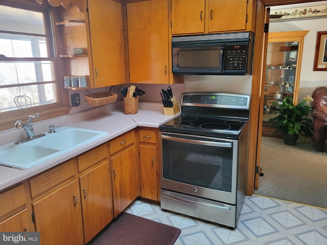 kitchen featuring sink, stainless steel electric range oven, and light tile floors