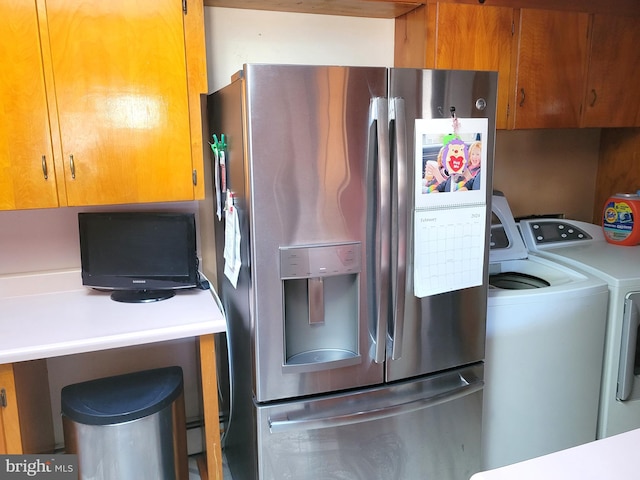 kitchen featuring stainless steel fridge with ice dispenser and washing machine and clothes dryer