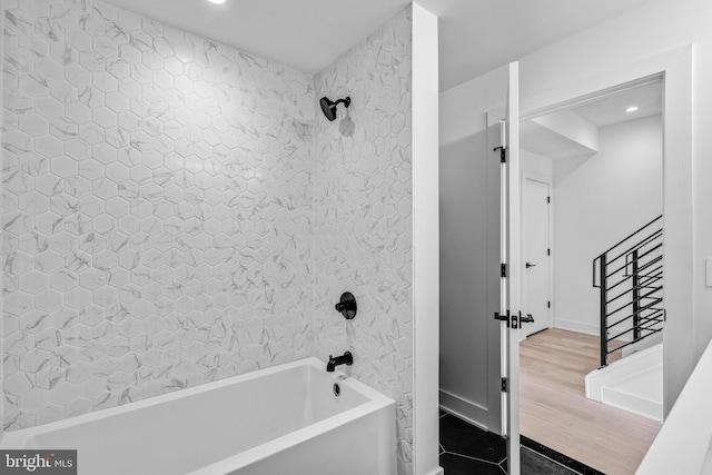 bathroom with hardwood / wood-style flooring and tiled shower / bath