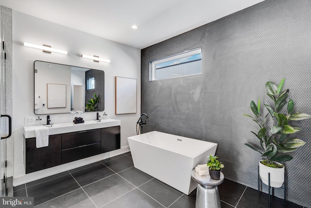 bathroom with a bathtub, double sink, oversized vanity, and tile flooring