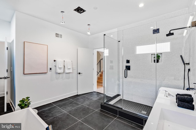 bathroom featuring tile floors, dual sinks, and separate shower and tub