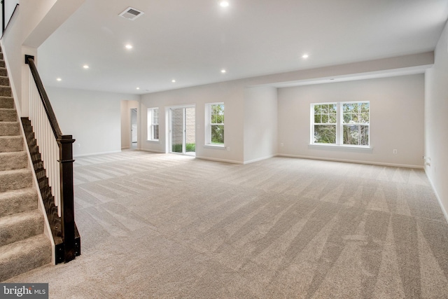 unfurnished living room with stairs, light carpet, visible vents, and recessed lighting