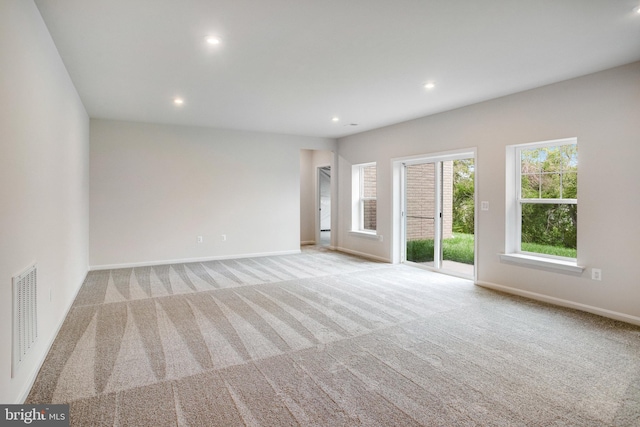 unfurnished room featuring baseboards, carpet floors, visible vents, and recessed lighting