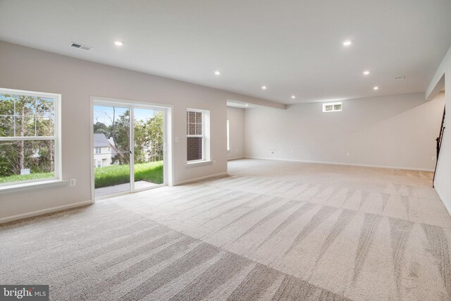 unfurnished living room with light carpet, baseboards, visible vents, and recessed lighting