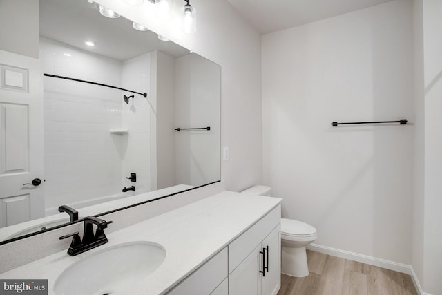 full bathroom featuring vanity, wood finished floors, toilet, and baseboards