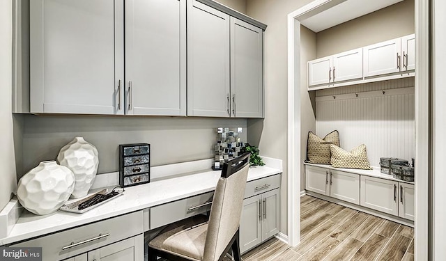 office featuring built in study area and light wood-style flooring