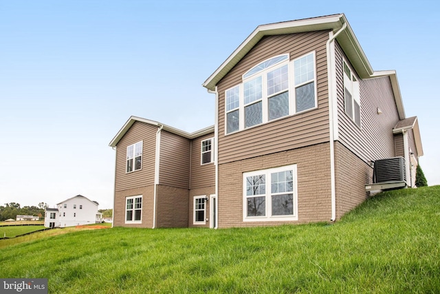 back of house with a yard and brick siding