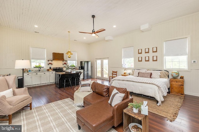 bedroom with french doors, ceiling fan, ornamental molding, stainless steel refrigerator, and dark wood-type flooring