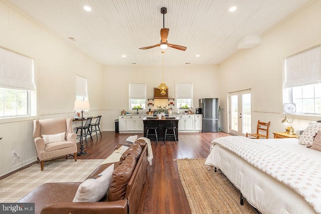 bedroom with stainless steel fridge, ceiling fan, and hardwood / wood-style flooring