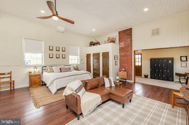 bedroom with brick wall, ceiling fan, and dark wood-type flooring