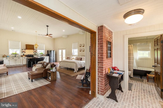 bedroom featuring stainless steel fridge, brick wall, sink, light hardwood / wood-style flooring, and ornamental molding