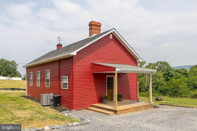 exterior space featuring a wooden deck, central AC, and a front lawn