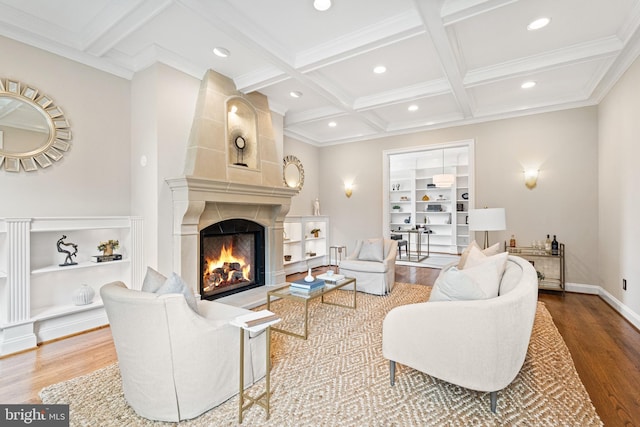 living room with a large fireplace, light hardwood / wood-style floors, coffered ceiling, and built in features