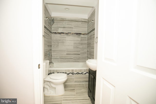 full bathroom with tiled shower / bath combo, vanity, tile patterned floors, and toilet