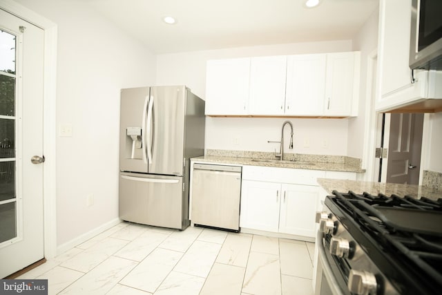 kitchen with light stone counters, sink, stainless steel appliances, and white cabinets