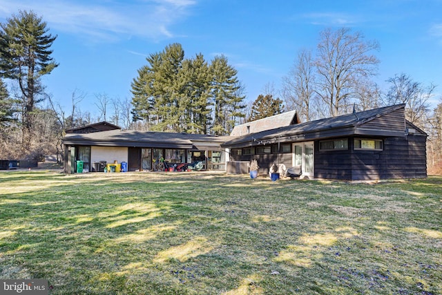 rear view of property featuring a lawn