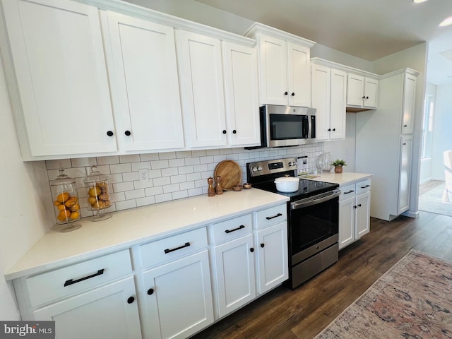 kitchen featuring dark hardwood / wood-style flooring, white cabinetry, backsplash, and appliances with stainless steel finishes