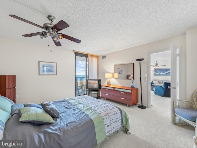 bedroom with light colored carpet, ceiling fan, and a textured ceiling