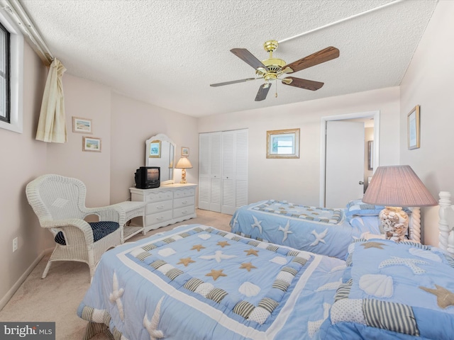 bedroom featuring ceiling fan, a textured ceiling, and light carpet