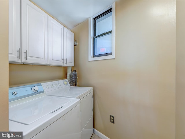 clothes washing area featuring cabinets and separate washer and dryer