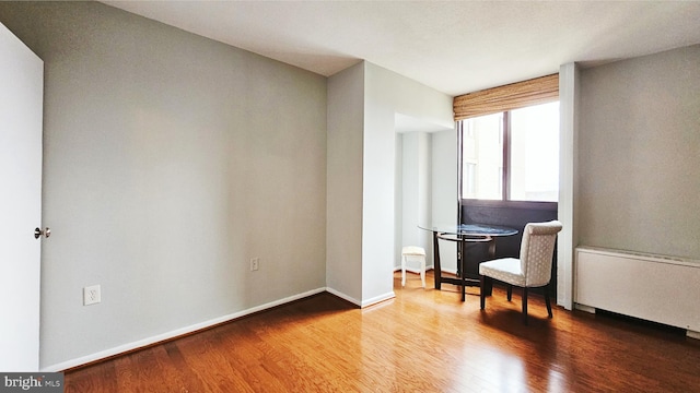 sitting room with wood-type flooring and radiator