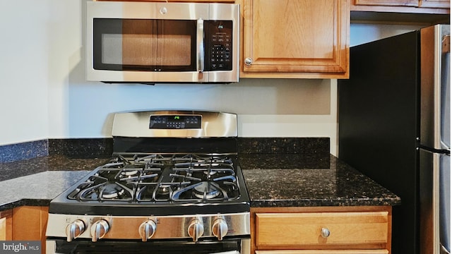 kitchen featuring dark stone counters and stainless steel appliances