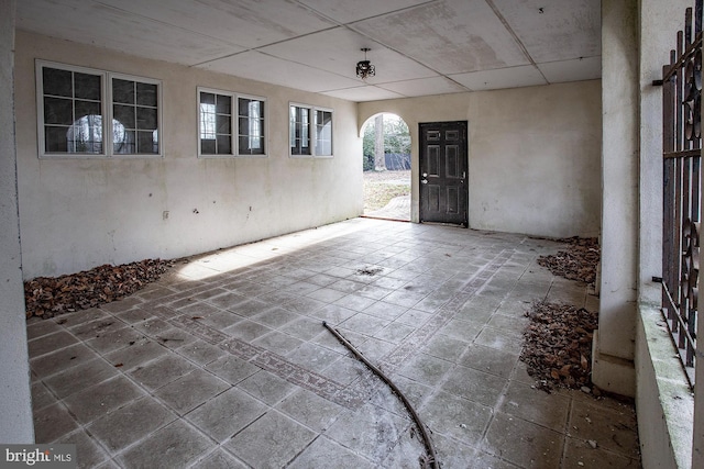 spare room featuring dark tile flooring and a drop ceiling