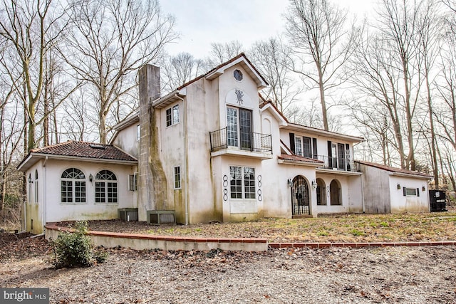 rear view of house featuring a balcony and central air condition unit