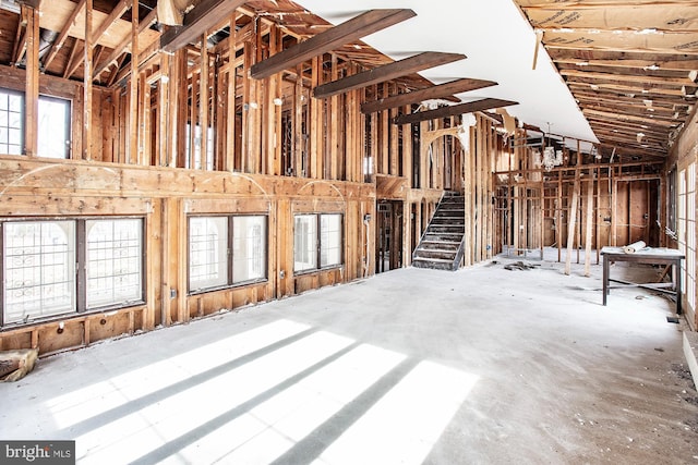 miscellaneous room featuring high vaulted ceiling, concrete flooring, and a wealth of natural light