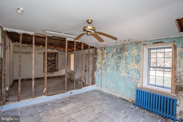 interior space with ceiling fan and radiator heating unit