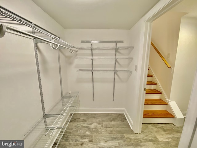 walk in closet with light tile floors