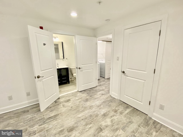 unfurnished bedroom with connected bathroom and light hardwood / wood-style flooring