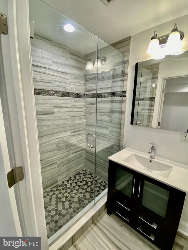 bathroom with vanity and a shower with shower door