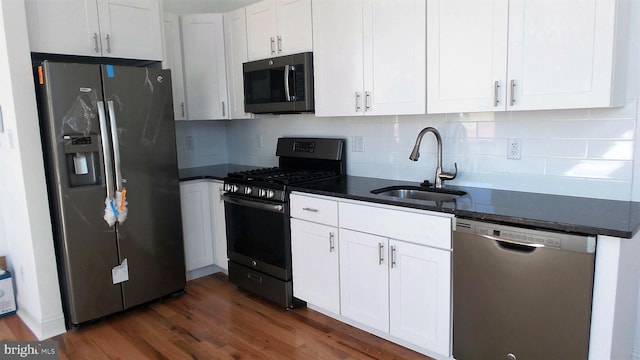 kitchen with dark hardwood / wood-style floors, sink, white cabinets, stainless steel appliances, and tasteful backsplash