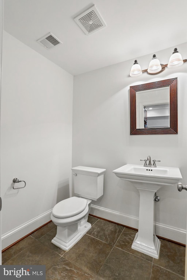 bathroom featuring toilet and tile floors