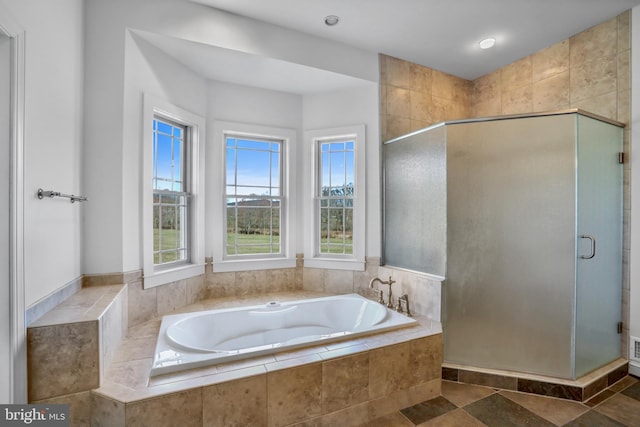 bathroom featuring shower with separate bathtub and tile floors