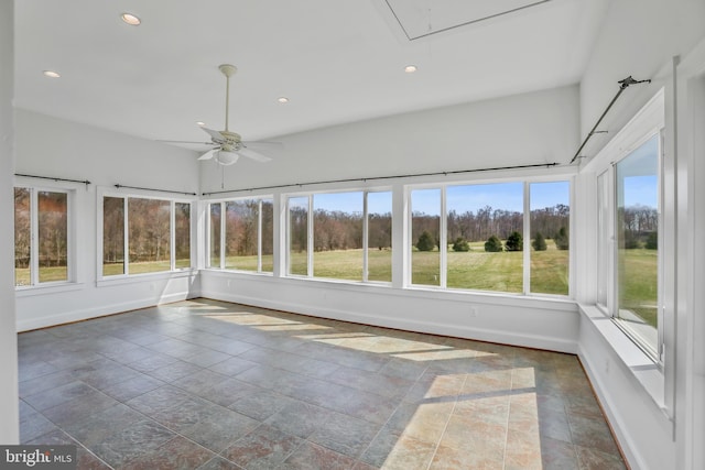 unfurnished sunroom featuring ceiling fan and a wealth of natural light